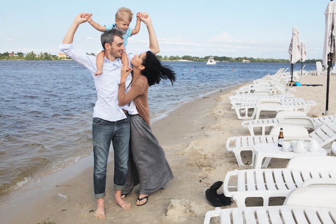 海ではしゃぐ若い夫婦とかわいい子供